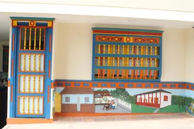 a building with blue and orange doors and a mural at Apartahotel Avverato in Guatapé