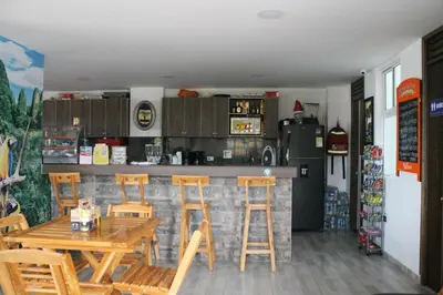 a kitchen with a table and chairs and a bar at Apartahotel Avverato in Guatapé