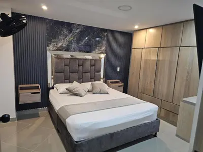a bedroom with a large bed with white sheets at Nuevo cerca poblado 301 in Medellín