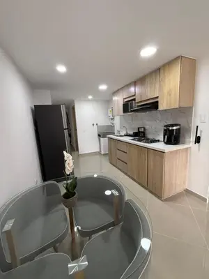 a kitchen with a table and some chairs in it at Nuevo cerca poblado 301 in Medellín