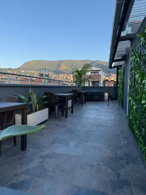 a patio with tables and benches on a building at Nuevo cerca poblado 301 in Medellín