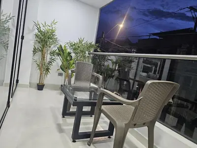 a table and chairs on a balcony with plants at Nuevo cerca poblado 301 in Medellín