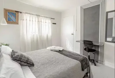 a white bedroom with a bed and a chair at El Poblado 4 Bedroom 3 Bathroom private Terrace in Medellín