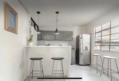 a kitchen with three bar stools and a refrigerator at El Poblado 4 Bedroom 3 Bathroom private Terrace in Medellín