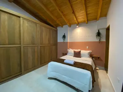 a bedroom with a large bed and wooden cabinets at Prosperity Room, Habitación doble - solo a una cuadra del parque in Carmen de Viboral