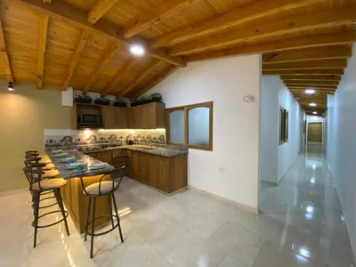 a kitchen with wooden ceilings and a bar with stools at Prosperity Room, Habitación doble - solo a una cuadra del parque in Carmen de Viboral