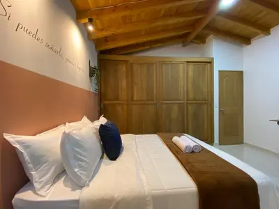 a bedroom with a bed with white sheets and pillows at Serenity Room, Habitación doble - solo a una cuadra del parque in Carmen de Viboral
