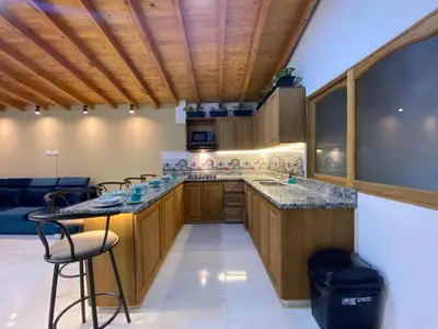 a kitchen with wooden cabinets and a counter with a bar at Serenity Room, Habitación doble - solo a una cuadra del parque in Carmen de Viboral