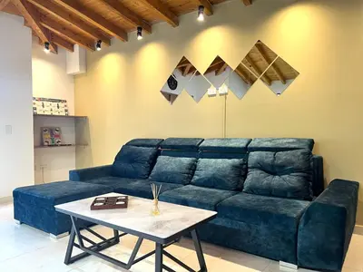 a living room with a blue couch and a table at Serenity Room, Habitación doble - solo a una cuadra del parque in Carmen de Viboral