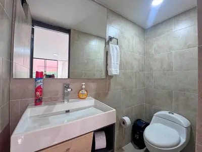 a bathroom with a sink and a toilet and a mirror at 5BR 232 m² apartment in El Poblado, El Tesoro in Medellín