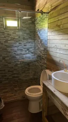a bathroom with a toilet and a sink at Rancho Forest Guatape in Guatapé