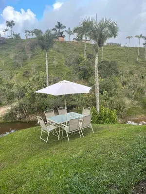 a table and chairs with a white umbrella at Rancho Forest Guatape in Guatapé