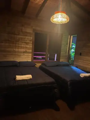 a bedroom with two beds and a chandelier at Rancho Forest Guatape in Guatapé