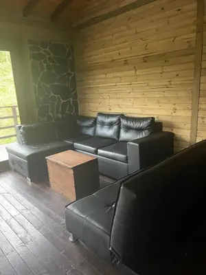 a living room with a leather couch and a table at Rancho Forest Guatape in Guatapé