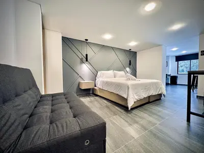 a bedroom with a bed and a couch at Loft 203 Laureles Le meilleur emplacement WIFI Toit in Medellín