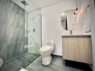 a bathroom with a toilet and a shower and a mirror at Loft 203 Laureles Le meilleur emplacement WIFI Toit in Medellín