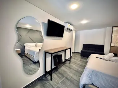a bedroom with a mirror and a bed and a couch at Loft 203 Laureles Le meilleur emplacement WIFI Toit in Medellín