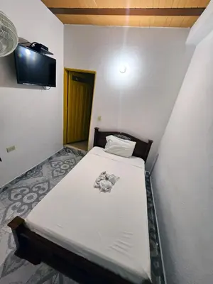 a bed in a room with a tv on the wall at Habitación sencilla con desayuno - La Casona Hotel in La Pintada