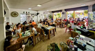 a group of people sitting at tables in a restaurant at Habitación sencilla con desayuno - La Casona Hotel in La Pintada