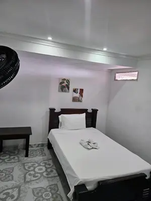 a bedroom with a white bed and a table at Habitación sencilla con desayuno - La Casona Hotel in La Pintada