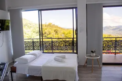 a bedroom with a bed and a large window at Hotel Curazao Natural Living in Cocorná