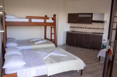 a bedroom with two bunk beds and a kitchen at Hotel Curazao Natural Living in Cocorná