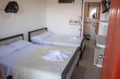 a bedroom with two beds with white sheets at Hotel Curazao Natural Living in Cocorná