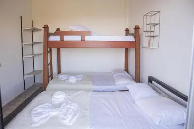 two bunk beds in a room with white sheets at Hotel Curazao Natural Living in Cocorná