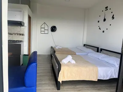 a bedroom with two beds and a blue chair at Hotel Curazao Natural Living in Cocorná