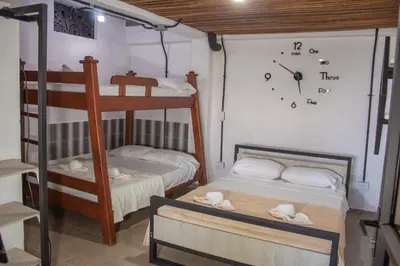 a room with two bunk beds and a clock on the wall at Hotel Curazao Natural Living in Cocorná