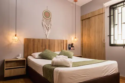 a bedroom with a bed with a wooden headboard at Hotel Casa 73 Deluxe in Medellín