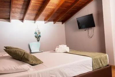 a bedroom with a bed and a flat screen tv at Hotel Casa 73 Deluxe in Medellín