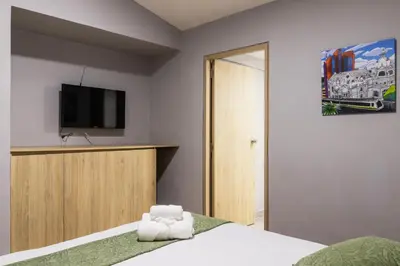 a bedroom with a bed with a tv on the wall at Hotel Casa 73 Deluxe in Medellín