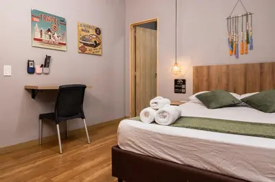 a bedroom with a bed with a desk and a chair at Hotel Casa 73 Deluxe in Medellín