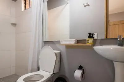 a white bathroom with a toilet and a sink at Hotel Casa 73 Deluxe in Medellín