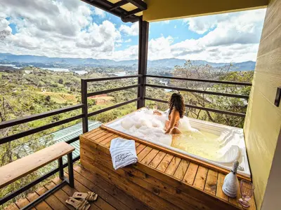a woman sitting in a bath tub on a balcony at Alto Sereno in Horizonte