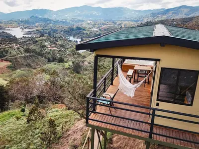 a house with a wrap around porch with a hammock at Alto Sereno in Horizonte