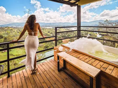 a woman in a white dress standing on a deck at Alto Sereno in Horizonte