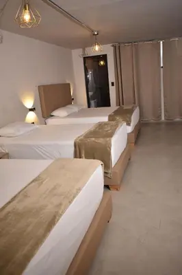 a row of beds in a hotel room at History Center Hotel in Medellín