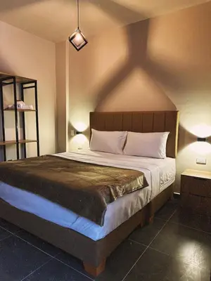 a bedroom with a large bed with two lamps at History Center Hotel in Medellín