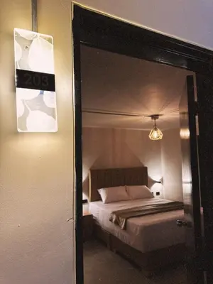 a reflection of a bedroom with a bed in a mirror at History Center Hotel in Medellín