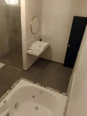 a bathroom with a tub and a sink and a mirror at History Center Hotel in Medellín