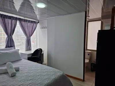 a bedroom with a bed and a large window at Habitación baño privado garaje moto, Manizales in Manizales