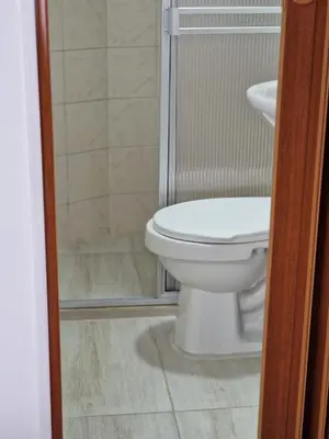 a bathroom with a white toilet and a shower at Habitación baño privado garaje moto, Manizales in Manizales