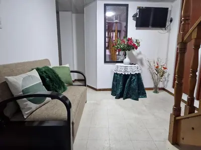 a living room with a couch and a table with flowers at Habitación baño privado garaje moto, Manizales in Manizales