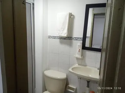 a bathroom with a toilet and a sink and a mirror at Habitación baño privado garaje moto, Manizales in Manizales