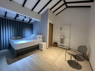 a bedroom with a bed and a table and chairs at Stylish 5-BR Apartment in Medellín's Trendiest Spot, Walk Everywhere! in Medellín