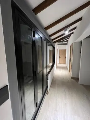 an empty hallway in an office building with glass windows at Stylish 5-BR Apartment in Medellín's Trendiest Spot, Walk Everywhere! in Medellín