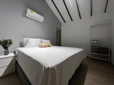 a white bedroom with a white bed with a white ceiling at Stylish 5-BR Apartment in Medellín's Trendiest Spot, Walk Everywhere! in Medellín