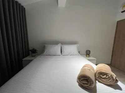a bedroom with a white bed with towels on it at Stylish 5-BR Apartment in Medellín's Trendiest Spot, Walk Everywhere! in Medellín
